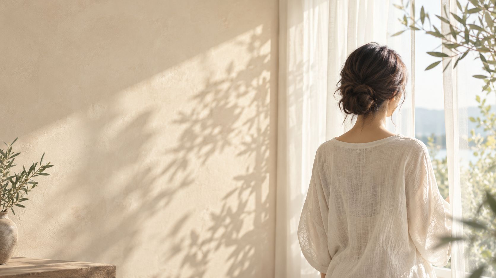 窓辺に立つ女性の後ろ姿